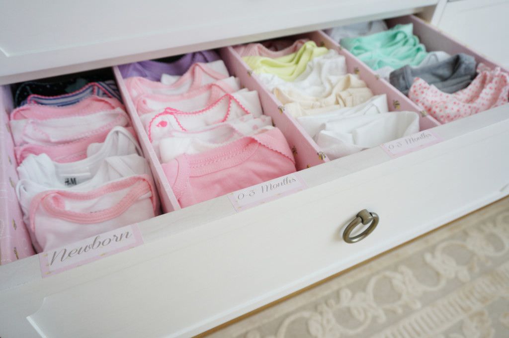 کشوهای لباس اتاق خواب نوزاد که به وسیله تقسیم کننده های چوبی بخش بندی شده است